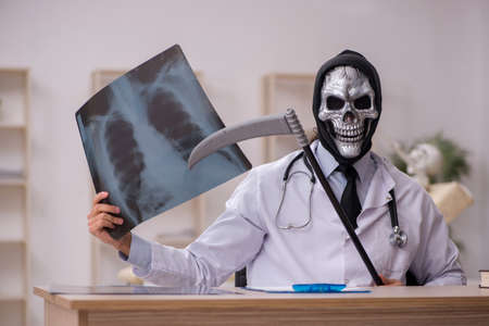 Devil doctor radiologist examining skeleton patientの写真素材