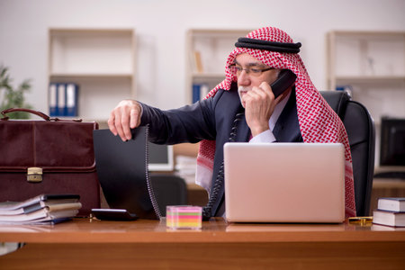 Aged arab businessman employee sitting at workplaceの写真素材