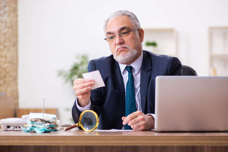 Old businessman employee in budget planning conceptの写真素材