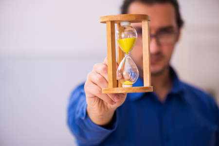 Young male teacher in time management concept