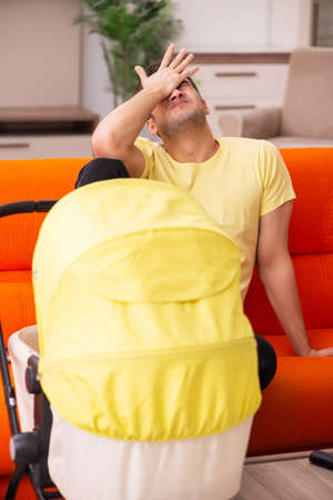 Young man looking after new born at homeの写真素材