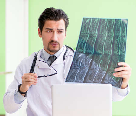 Doctor radiologist looking at x-ray scan in hospitalの写真素材