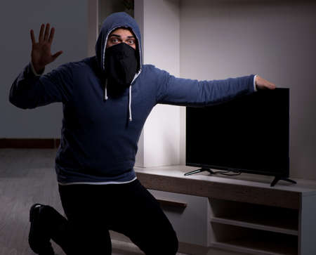 Burglar thief stealing tv from apartment houseの写真素材