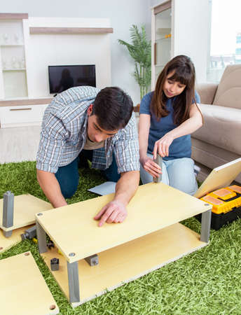 Young family assembling furniture at new houseの写真素材