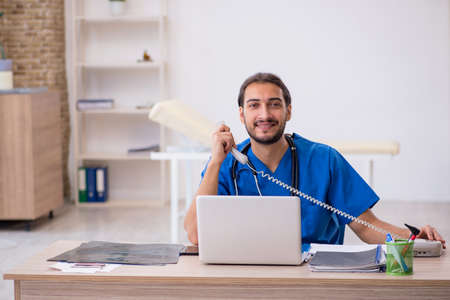 Young male doctor in telemedicine conceptの写真素材