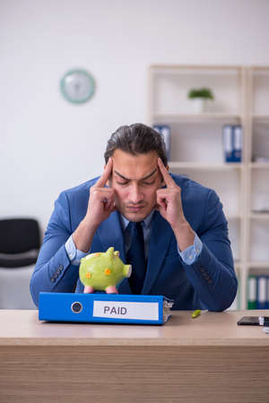 Young male employee in budget planning conceptの写真素材
