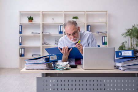 Old male accountant in budget planning concept in the officeの写真素材