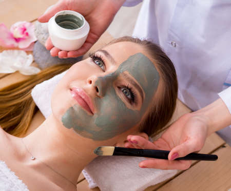 Young woman in spa health concept with face maskの写真素材