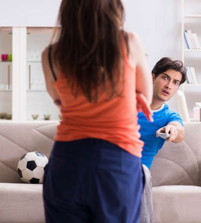 Wife unhappy that husband is watching footballの写真素材