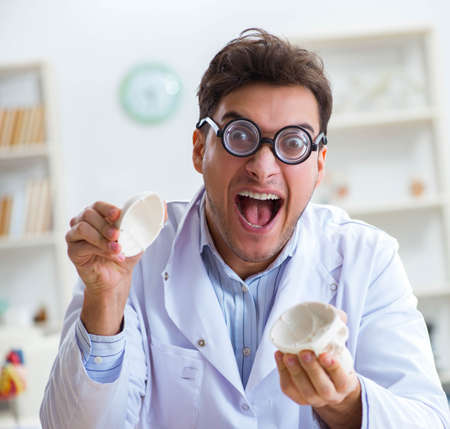 Crazy doctor studying human skeletonの写真素材