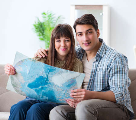Young family discussing travel plans with map
