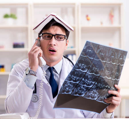 Young doctor looking at x-ray images in clinic