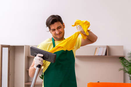 Young male contractor cleaning the house indoorsの写真素材