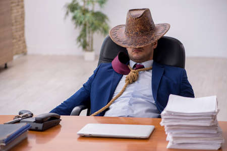 Young cowboy businessman working at workplaceの写真素材