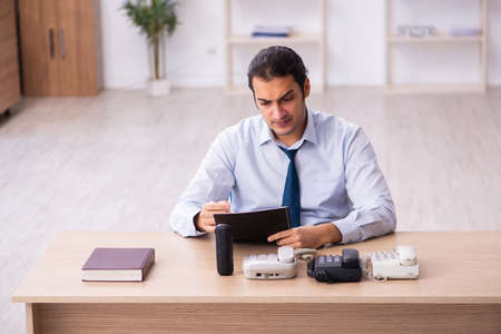 Young male call center operator working at his desk