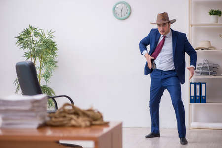 Young cowboy businessman working at workplaceの写真素材