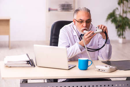 Aged male doctor working in the clinicの写真素材