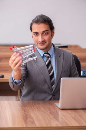 Young male employee in ecommerce conceptの写真素材