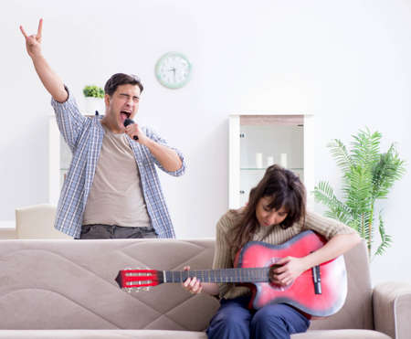 Young family singing and playing music at homeの写真素材
