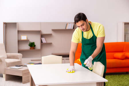 Young male contractor cleaning the house indoors