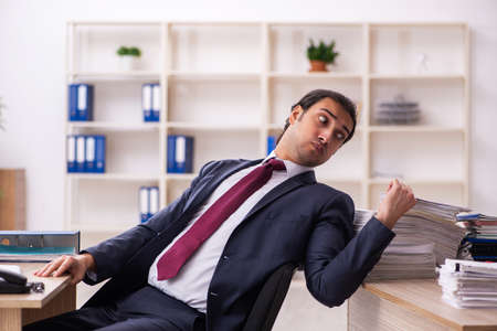 Young male employee unhappy with excessive workの写真素材