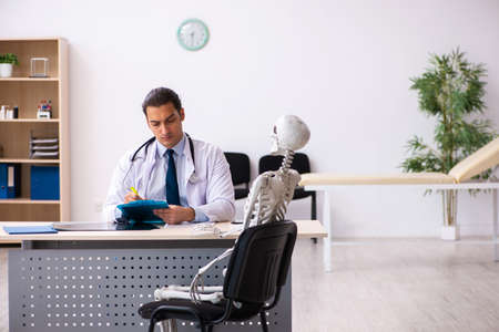 Young male doctor and skeleton patient in the clinicの写真素材