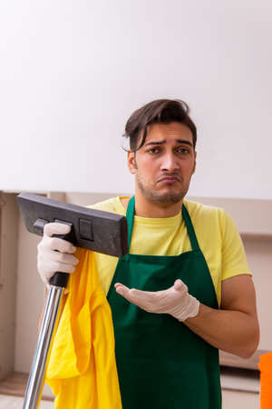 Young male contractor cleaning the house indoorsの写真素材