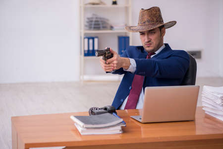 Young cowboy businessman working at workplaceの写真素材