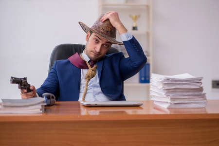 Young cowboy businessman working at workplaceの写真素材