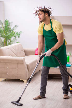 Young male contractor wearing prickly wreath on head cleaningの写真素材