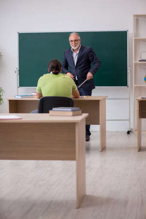 Aged teacher and male student in the classroomの写真素材