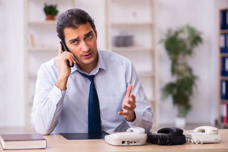 Young male call center operator working at his deskの写真素材