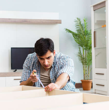 Man assembling furniture at homeの写真素材