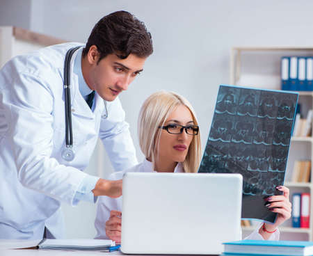 Two doctors examining x-ray images of patient for diagnosis