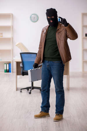 Young man in balaclava stealing vaccine from the labの写真素材