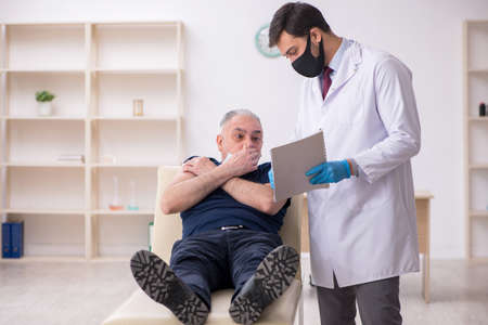 Old male patient visiting young male doctor in vaccination conceの写真素材