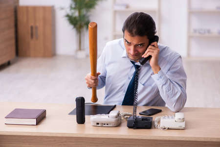 Young male call center operator working at his deskの写真素材