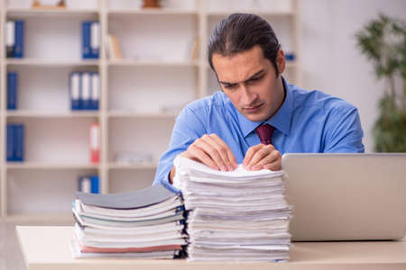 Young male employee unhappy with excessive workの写真素材