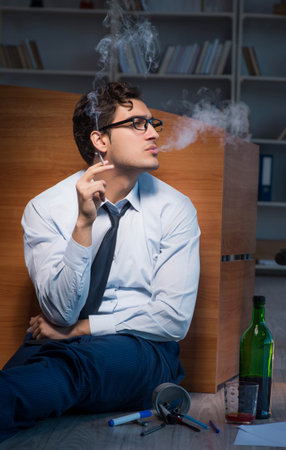 Stressed businessman working overtime in depressionの写真素材
