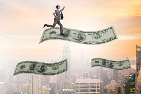 Businessman flying on hundred dollar banknoteの写真素材