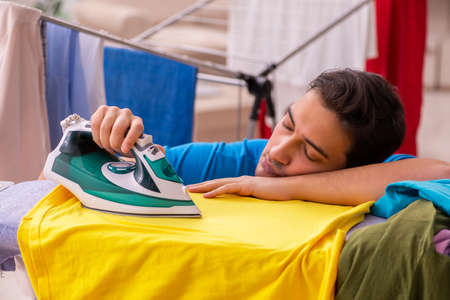 Young man husband doing ironing at homeの写真素材