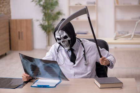 Devil doctor radiologist examining skeleton patientの写真素材