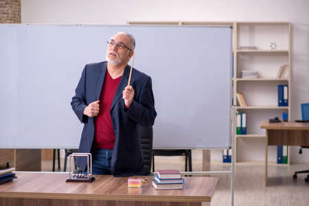 Old teacher physicist sitting in the classroomの写真素材