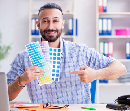 Young designer working in his studio on new projectの写真素材