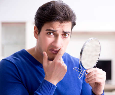 Man panicking because of pimples on the skinの写真素材
