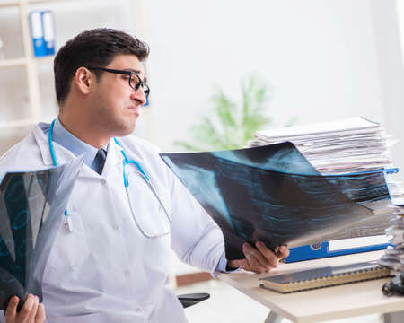 Tired radiologist with x-ray image in hospital