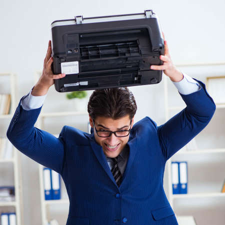 Businessman angry at copying machine jamming papers