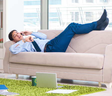 Businessman taking work home and working overtimeの写真素材