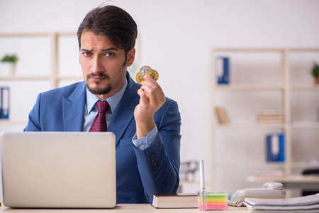 Young man earning money via Internet in cryptocurrency conceptの写真素材