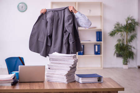 Young businessman employee unhappy with excessive work in the officeの写真素材